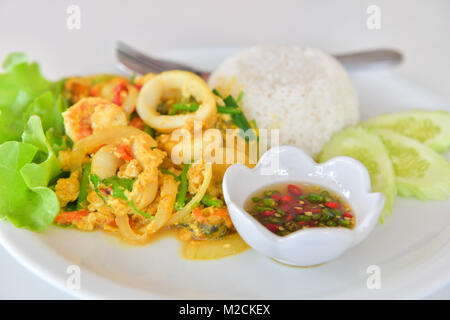 Rühren gebratener Tintenfisch mit Curry und Reis, traditionelle thailändische Küche. Stockfoto