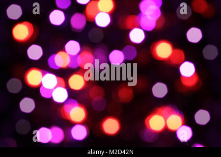Verschwommenes Weiß, Rosa, Rot, Gelb und Magenta leuchtet auf schwarzem Hintergrund Stockfoto