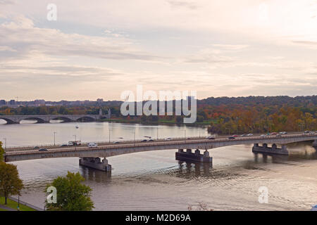 Washington DC Panorama entlang der Potomac River bei Sonnenuntergang im Herbst, USA. Städtische Landschaft mit Brücken, Autos und Freizeit Park in der Nähe des Potomac Stockfoto