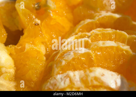 Nahaufnahme von in Scheiben geschnittenen Orangen in einer Glasschale in der Sonne. Stockfoto