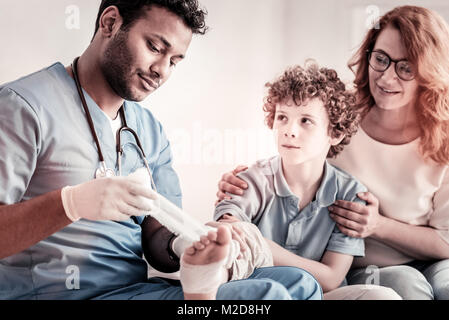 Schwere Arzt Anwendung Verband auf jugendlich Fuß Stockfoto