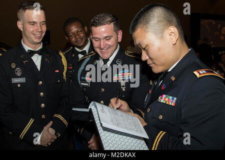 In ihrer Armee Service Uniformen gekleidet, Soldaten aus dem 143d Sustainment Command (Auslandseinsätze) unterzeichnen das schwarze Buch während der während der Generalmajor Francisco A. Espaillat Sieg Kugel an den Rosen Shingle Creek Resort in Orlando, Fla., Dez. 16, 2017 durchgeführt. Der Sieg Ball präsentiert eine einzigartige Gelegenheit für die Soldaten, die im gesamten Gebiet der Befehl von Arbeitsgängen zugeordnet ihre Anzüge, Kleider oder Kleid uniformen Don und umgeben sich mit neuen und bekannten Gesichtern in einem lustigen und freundlichen Atmosphäre. (U.S. Armee Stockfoto