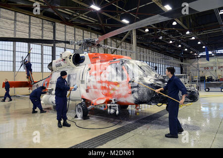 Coast Guard Air Station Kodiak Flieger waschen einem MH-60 Jayhawk Helikopter Jan. 3, 2018, im Hangar 3 am Air Station Kodiak, Alaska. Routinemäßige Wartung durch Waschen ein Flugzeug entfernt Salzwasser Rückstände und Schmutz und sorgt für eine Reduzierung der Korrosion. Us-Küstenwache Stockfoto