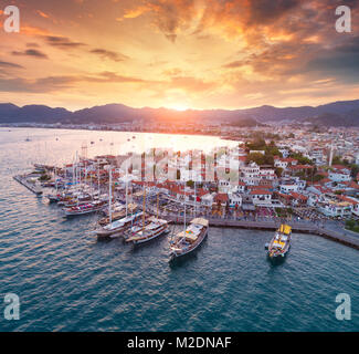 Luftaufnahme der Boote und Yachten und schöne Architektur bei Sonnenuntergang in Marmaris, Türkei. Landschaft mit Yachten in der Marina Bay, Meer, Stadt, Berge, Co Stockfoto