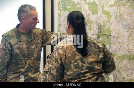 Während einer Übung in Riga, Lettland, Maj Todd poltert, ein Mitglied der Michigan National Guard, 507Th Engineer Unternehmen, unterstützt Kapitän A. Barkane, 3. Brigade, der lettischen National Guard, Jan. 16, 2018, beim Lernen über die militärischen Entscheidungsfindung (Mdmp). Mitglieder der Michigan National Guard und der Lettischen Nationalen Schutz durch regelmäßige Schulung und Informationsaustausch wie DOD Partnerschaft Programm verbündeten, eine Beziehung, die feiert 25 Jahre Geschichte im Jahr 2018. (Michigan National Guard Stockfoto