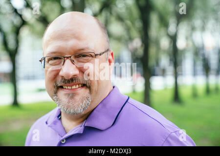 Portrait von lächelnden kaukasischen Mann im Park Stockfoto