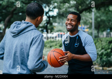 Lächelnd schwarze Männer Basketball spielen Stockfoto