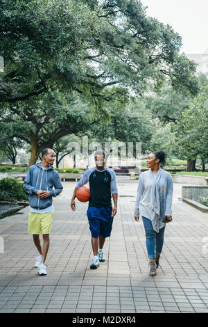 Lächelnd schwarzen Freunden Wandern im Park mit Basketball Stockfoto