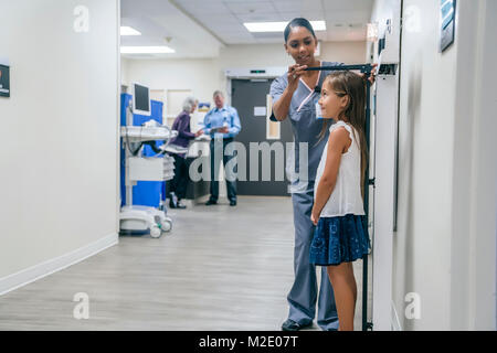 Krankenschwester Messhöhe von Mädchen im Krankenhaus Stockfoto