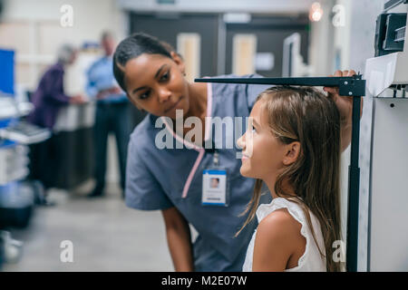 Krankenschwester Messhöhe von Mädchen im Krankenhaus Stockfoto