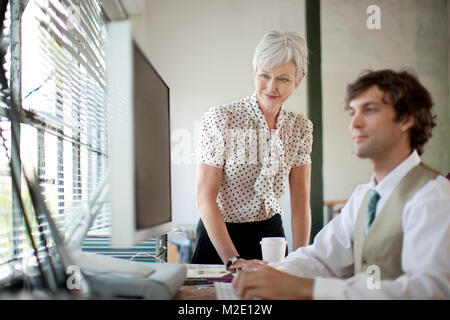 Geschäftsleute, die mit Computer im Büro Stockfoto