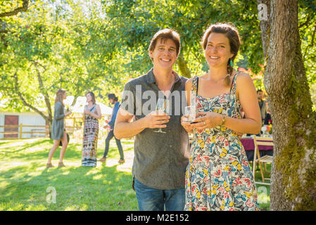 Portrait von lächelnden Kaukasischen paar Wein trinken im Freien Stockfoto