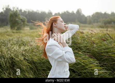 Wind die Haare der kaukasischen Frau im Feld Stockfoto