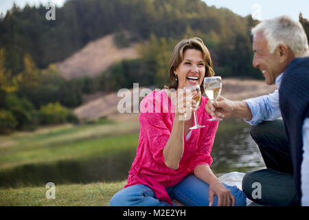 Paar Toasten mit Wein und Lachen Stockfoto