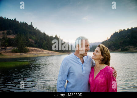 Lächelndes Paar in der Nähe von See Stockfoto