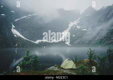 Camping Zelt in der Nähe von Fluss im Nebel Stockfoto