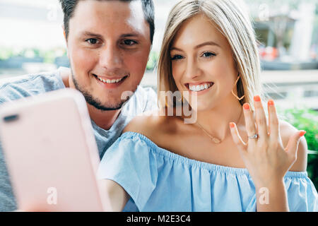 Kaukasische Paar für Handy selfie zeigen Engagement Ring posiert Stockfoto