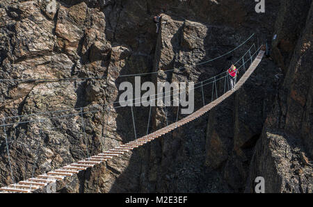 Kaukasische mann Seil überqueren der Brücke am Berg Stockfoto