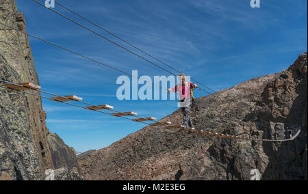 Kaukasische mann Seil überqueren der Brücke am Berg Stockfoto