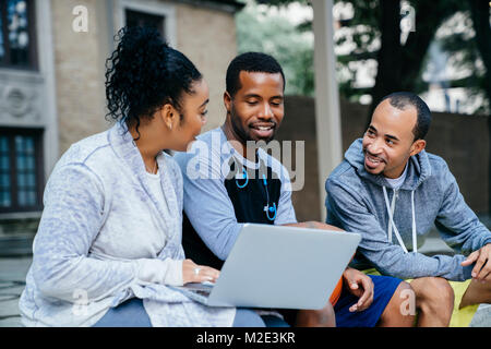 Schwarzen Freunden sitzen im Freien mit Laptop Stockfoto