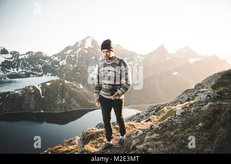 Kaukasische Mann, der Kamera in der Nähe von Mountain Lake Stockfoto