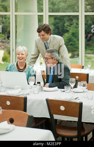 Geschäftsleute mit Laptop im Restaurant Stockfoto