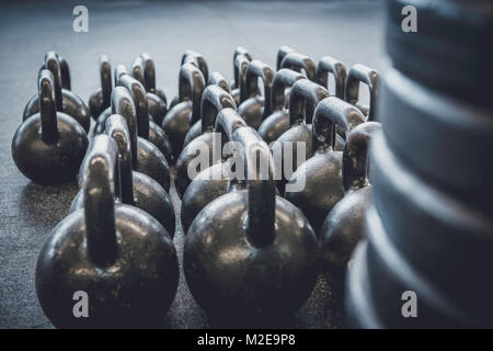 Detailaufnahmen von Fitnessgeräten in der Turnhalle. Verschiedene Gewichte und Wasserkocher Glocken. Stockfoto