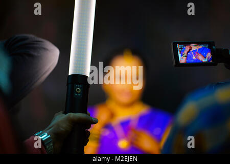 Der Fotograf Werkzeug eines Ort tragbare Licht verwendet, nur das Gesicht der Person in den photoframe zu leuchten. Der Kameramann hat feste Kamera auf Braut Stockfoto