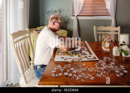 Eine ältere, oder älteren Menschen mit Demenz arbeitet ein Puzzle seine geistigen Fähigkeiten zu schärfen. Oklahoma, USA. Stockfoto