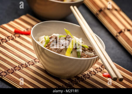 Traditionelle Pho Bo vietnamesische Suppe mit Rindfleisch in weiße Platte und Essstäbchen Stockfoto