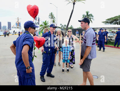 Chief Warrant Officer Christian Sova der Coast Guard Cutter Kimball (WMSL 756) grüsst seine Familie und shipmates bei Coast Guard Base Honolulu Honolulu Jan. 4, 2018. Sova ergänzt die Crew der Coast Guard Cutter Joseph Gerczak (WPC1126) auf dem Kalifornien nach Hawaii bein Ihrer 42-tägigen Transit zu Ihrem neuen homeport von Key West, Florida, wo der Cutter deliveredi wurde. (U.S. Küstenwache Stockfoto