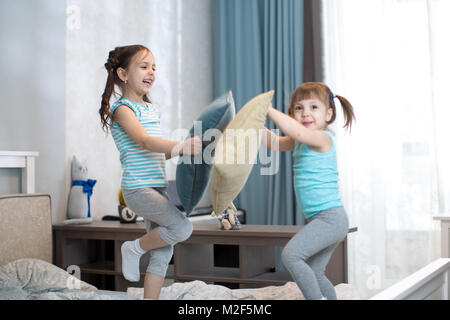 Kids Mädchen haben Spaß beim Spielen mit Kissen im Schlafzimmer zu Hause Stockfoto