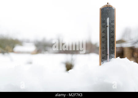 Thermometer auf Schnee zeigt niedrigen Temperaturen unter Null. Kalte Winter Wetter unter Null. Stockfoto