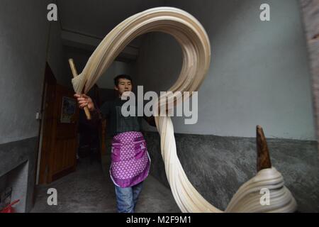 (180207) - Peking, Februar 7, 2018 (Xinhua) - Datei Foto auf 18.01.2016 zeigt einen Dorfbewohner versuchen, Sirup Matang, eine Art von handgemachten Süßigkeiten, in Chunjing Dorf Hebrew County im yuqing Grafschaft zu reißen, im Südwesten Chinas Provinz Guizhou. Nach traditionellen kulturellen Elemente und Zoll, einige unverzichtbare Gerichte mit symbolischen Bedeutungen werden während der Spring Festival. Sie sind feierliche Prozesse und süße Erinnerungen für die, die Leben und Arbeit von zu Hause weg. Spring Festival, oder besser als chinesische Mondjahr genannt, ist das wichtigste Festival für alle Chine Stockfoto