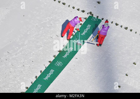 Allgemein, Helfer entfernen Schnee mit Besen im Schanzenauslauf, Skijjumping, Skispringen, Training am 08.02.2018, Olympische Winterspiele 2018, vom 09.02. - 25.02.2018 in PyeongChang/Suedkorea. | Verwendung weltweit Stockfoto