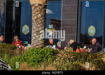 Die Menschen saßen draußen Visto Lounge Cafe in der Sonne im Februar 2018. Sonnigen morgen bei Torquay, Torbay, Devon, Großbritannien. Stockfoto