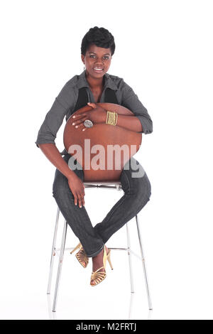 Afrikanische Frauen in ungezwungener einheitliche sitzen auf einem Stuhl Stockfoto