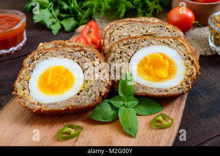 Fleisch Schnitzel mit gekochtem Ei, Stücke auf einem dunklen Hintergrund. Mini Fleisch rollen. Schottische Schnitzel. Stockfoto