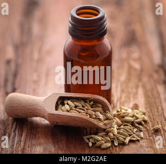 Fenchel Samen mit ätherischen Öl in eine Flasche auf natürliche Oberfläche Stockfoto