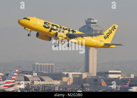 Spirit Airlines helle gelbe Airbus A320 vom Los Angeles International Airport, der Flugverkehrskontrolle im Hintergrund. Stockfoto