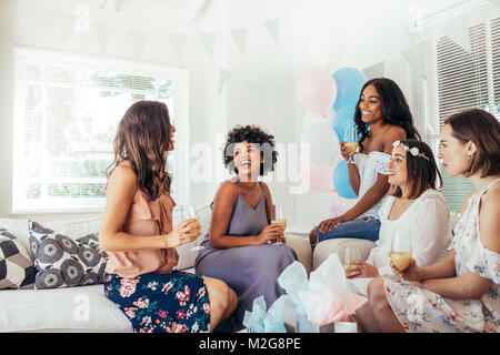 Multirassischen Frauen zusammen an einem Babysitting Dusche und Lachen. Weibliche Freunde Spaß an Baby Dusche. Stockfoto