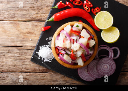 Traditionelle ceviche Fisch mit Gemüse und Kalk in der Nähe auf einem Teller auf den Tisch. horizontal oben Ansicht von oben Stockfoto
