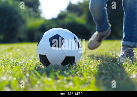 In der Nähe der Kugel im Gras liegend Stockfoto