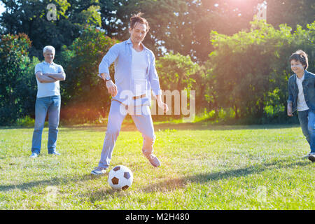 Unterstützende Familie Fußball spielen zusammen Stockfoto