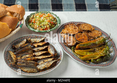 Marokkanische Essen mit Gefüllte Sardinen, Gerichte mit Gemüse und ein Korb mit Brot Stockfoto