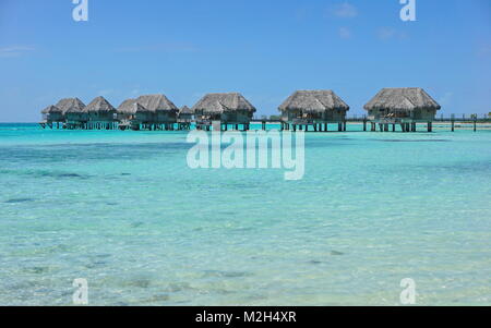 Tropische Bungalows über dem Wasser in einer Lagune mit türkisblauem Wasser, Tikehau Atoll, Tuamotus, Französisch Polynesien, Pazifik, Ozeanien Stockfoto