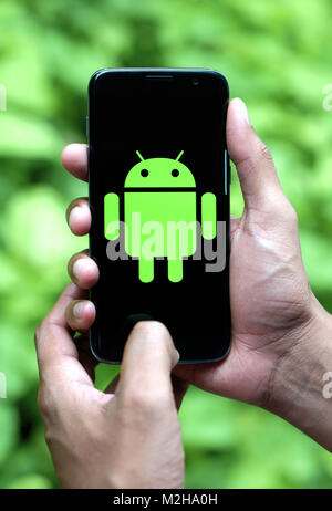 Mann mit Android Handy mit Logo Stockfoto