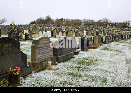 Grabsteine in düsteren Gegensatz gegen die dünne Schicht Schnee in der clandeboye Friedhof Bangor Northern Ireland an einem kalten Wintermorgen Stockfoto