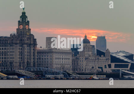 Die anglikanische Kathedrale von Liverpool in der Ferne mit einem frühen Morgen orange Sun über die Waterfront von Liverpool steigt. Stockfoto