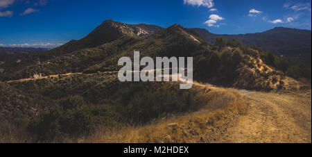 Malerischer Blick auf den Red Rock Canyon Trail schlängelt sich durch den Canyon mit Felsformationen an einem sonnigen Tag mit blauen Himmel und Wolken, Red Rock Canyon Stockfoto